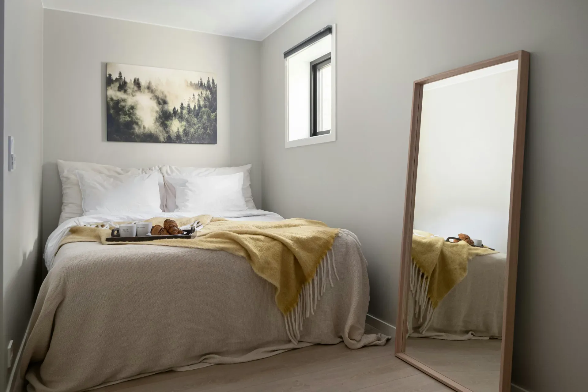 A bedroom with a bed and a large mirror