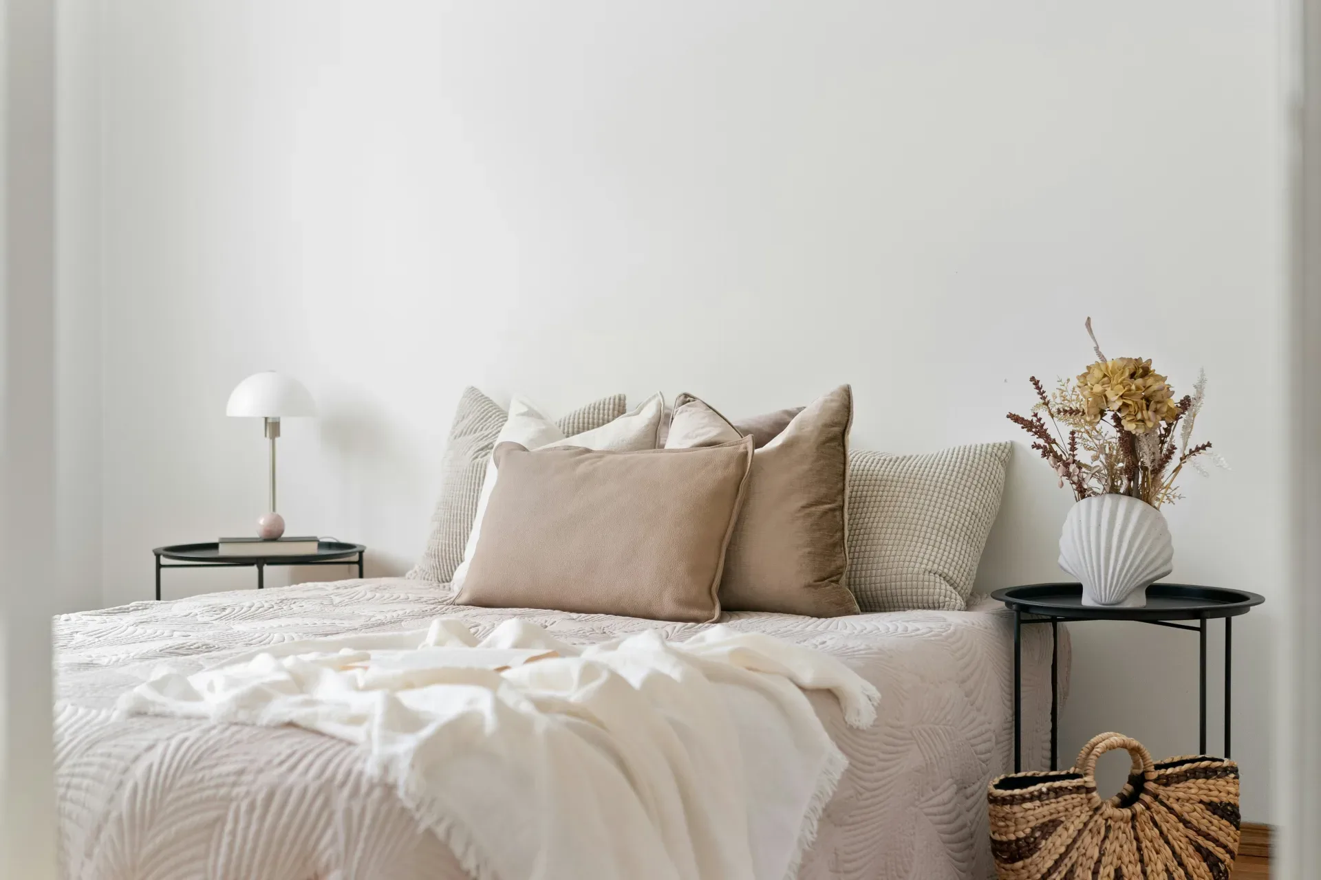 A bedroom with a white bed and white walls
