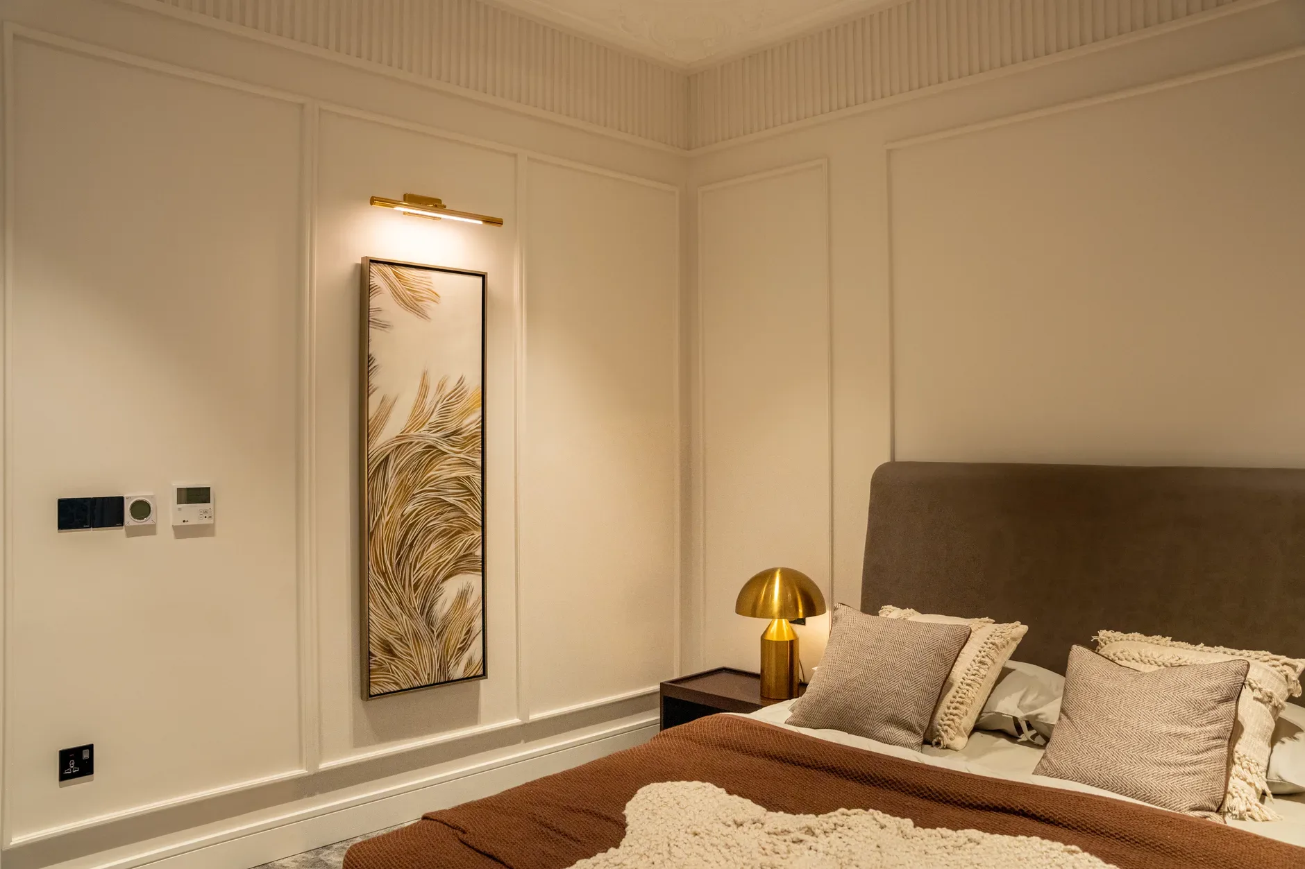 A cozy modern bedroom featuring minimalist decor with neutral tones and stylish lighting.