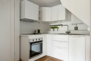 A kitchen with white cabinets and a stove top oven