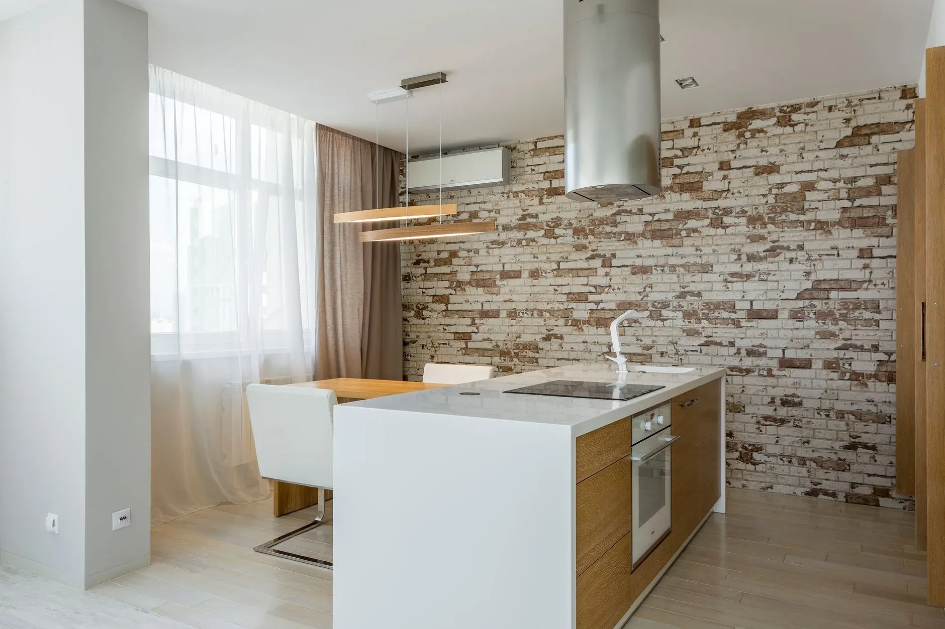 Contemporary open-plan kitchen with sleek design elements and a rustic brick accent wall.