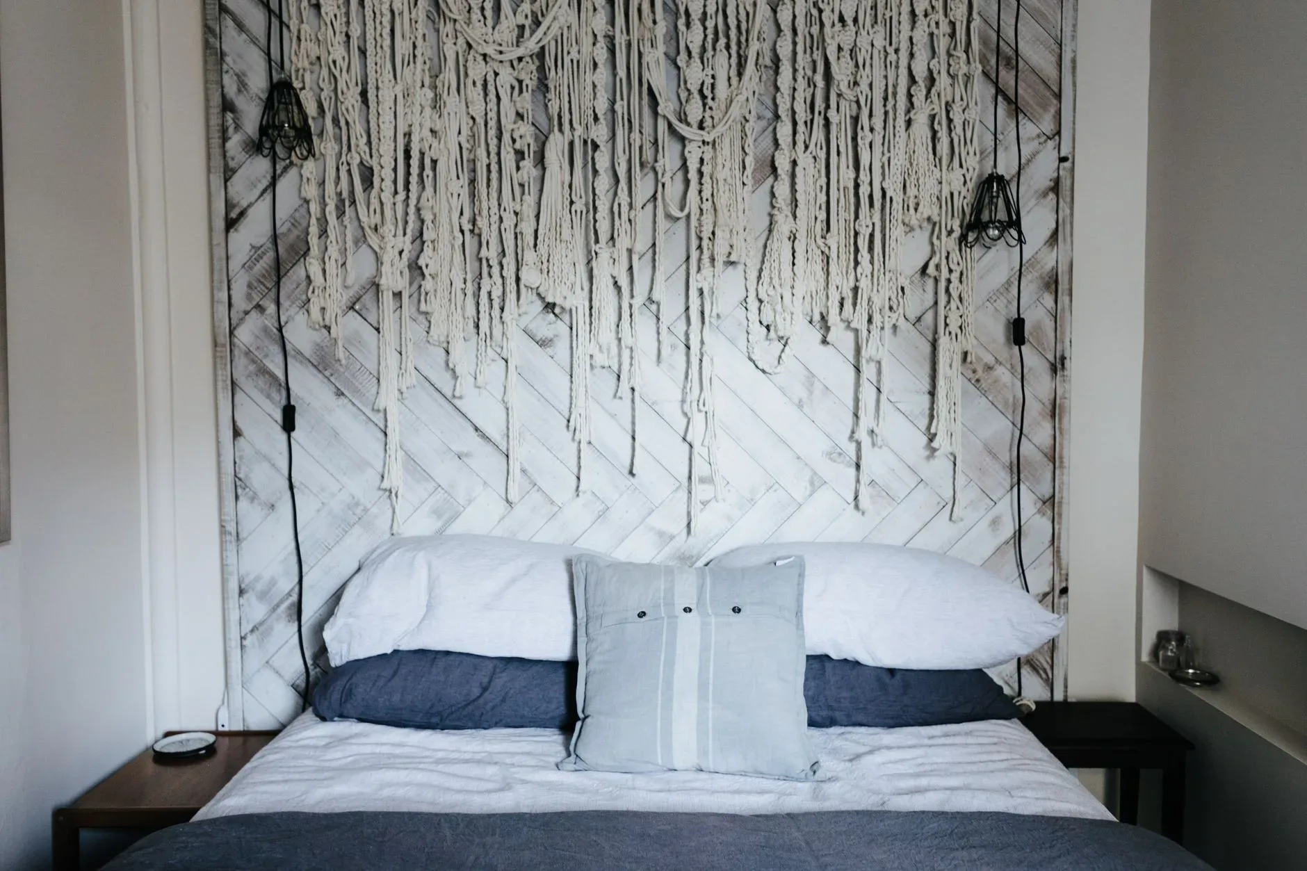 Cozy bedroom interior featuring a unique hanging decoration on a wooden headboard.
