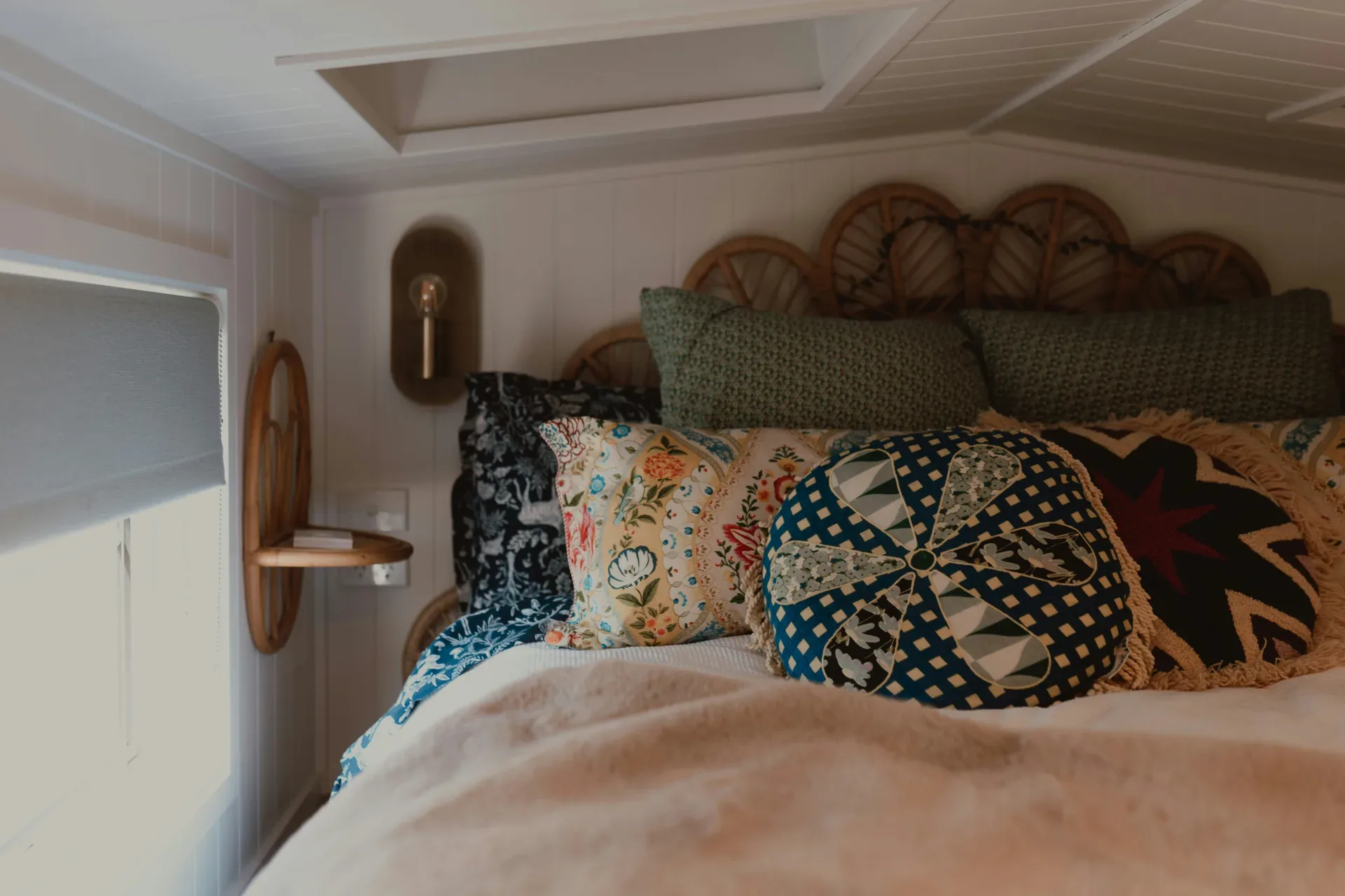 Cozy bedroom with decorative pillows and a wicker headboard.