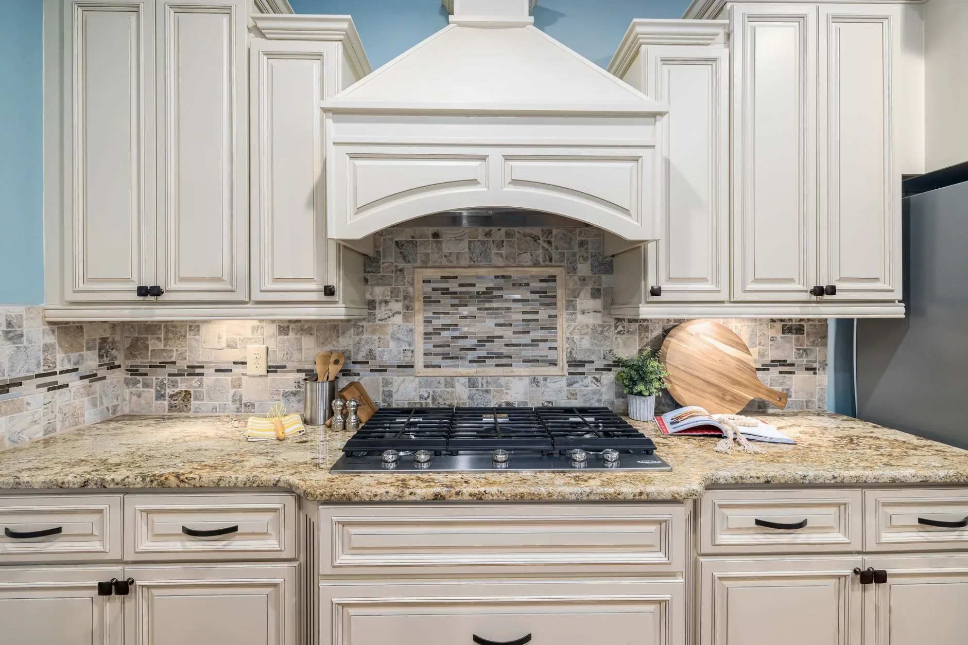 Elegant kitchen interior featuring marble countertops, wooden cabinets, and modern appliances.