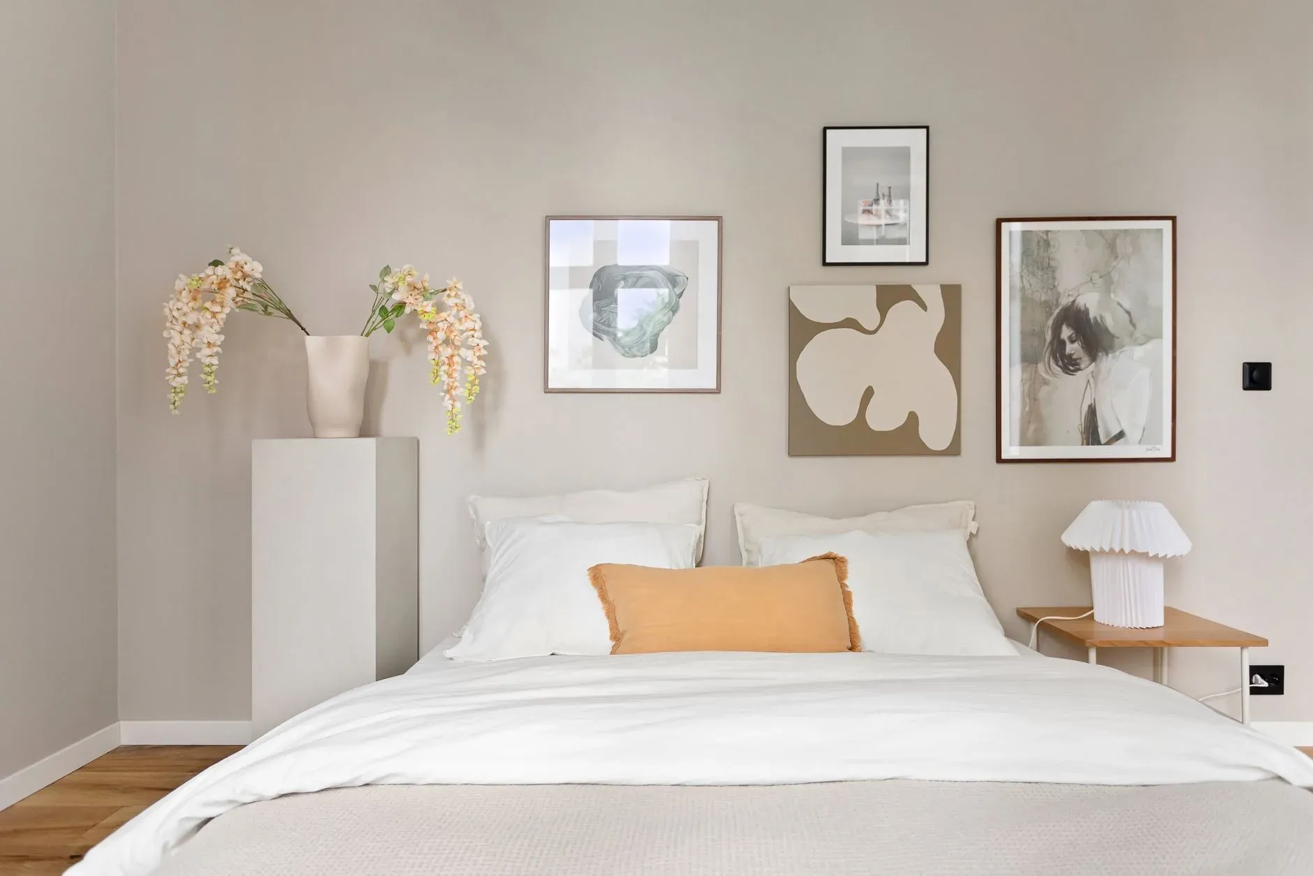 Elegant minimalist bedroom with modern artwork and decor, exuding calmness.