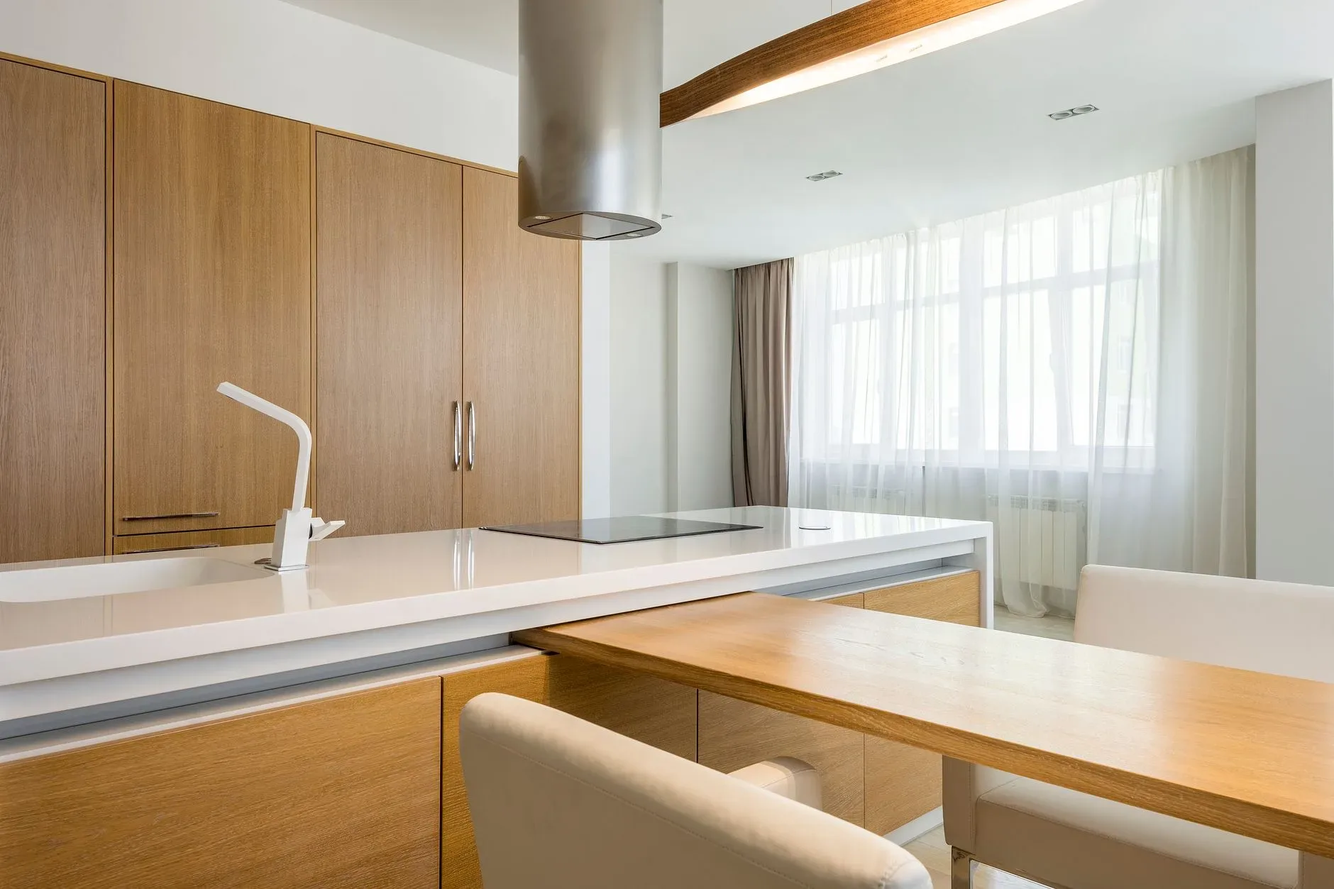 Interior of contemporary spacious kitchen with wooden table and chairs and comfortable chairs