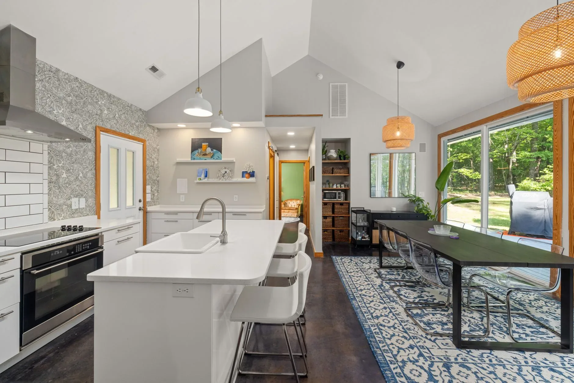 Spacious modern kitchen with dining area featuring large windows and natural light.
