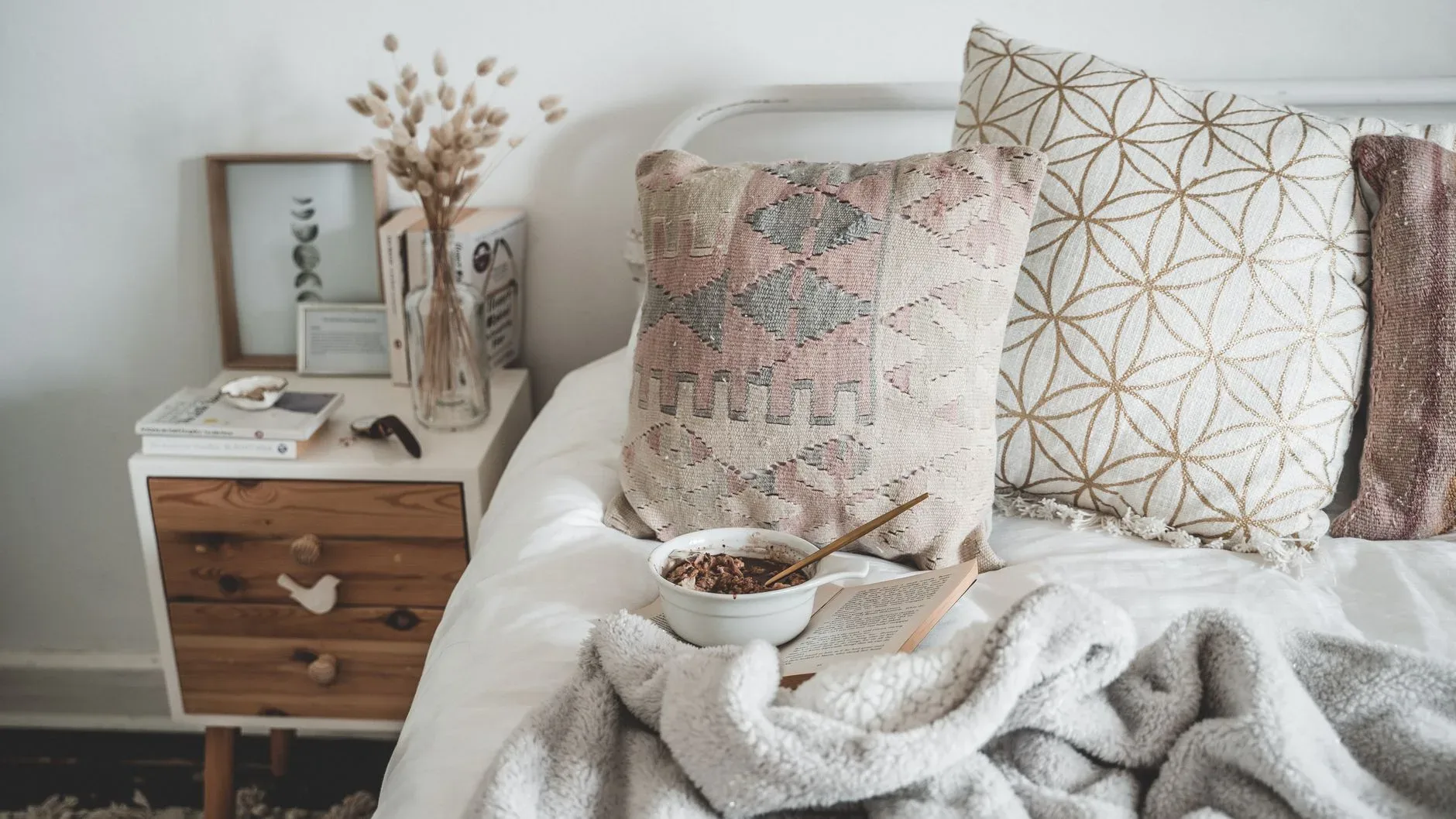Warm and inviting bedroom scene featuring pillows and a breakfast setup, perfect for a relaxed morning.