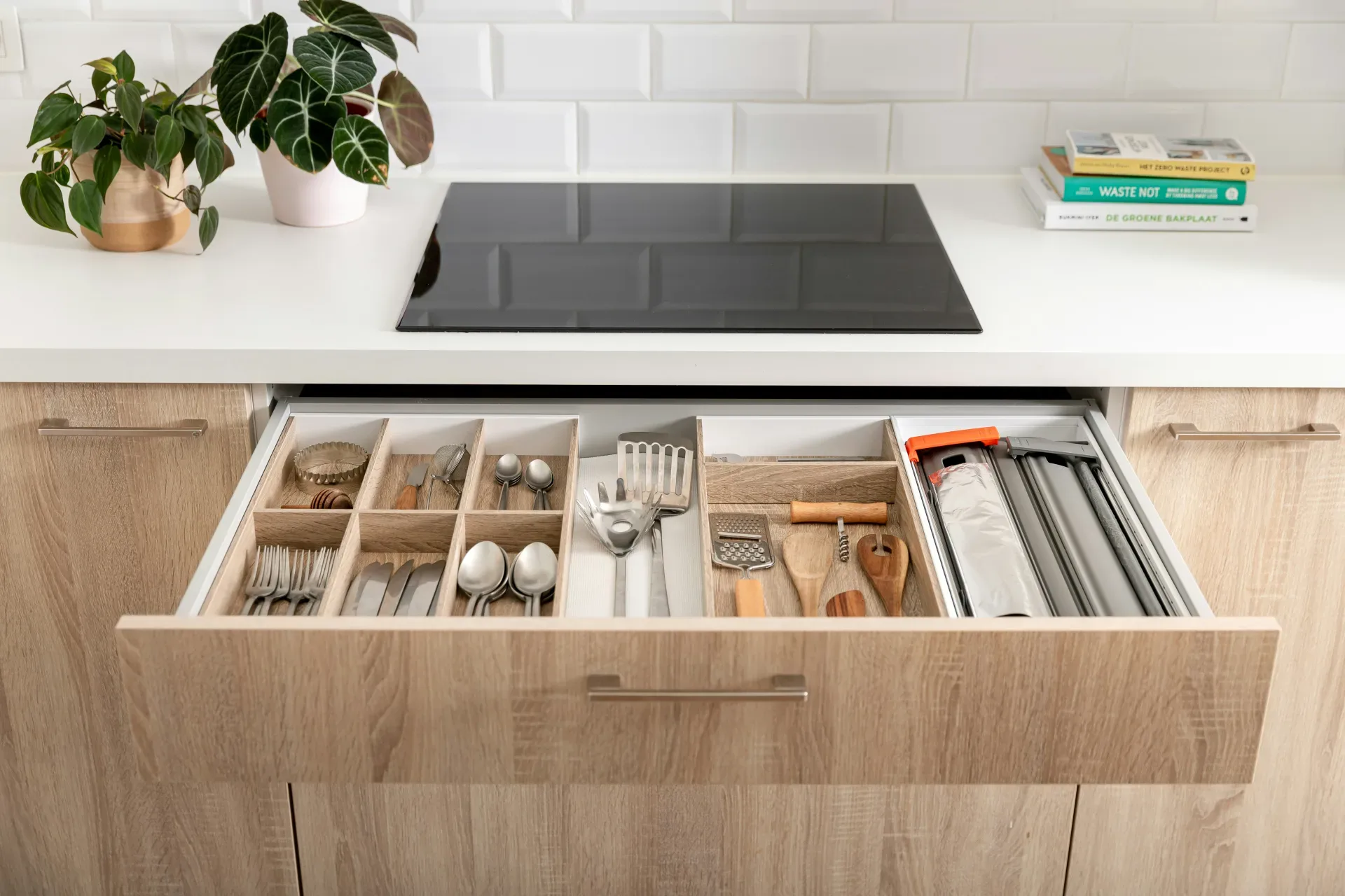 a kitchen drawer filled with utensils and a potted plant
