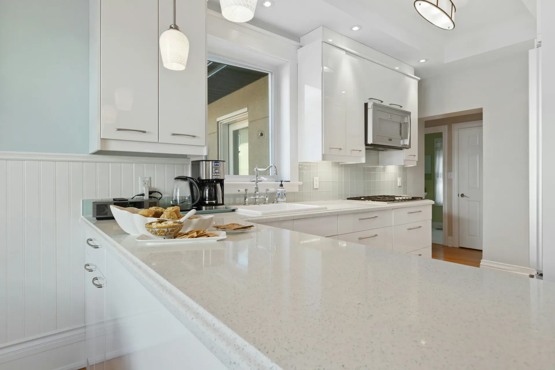 a kitchen with white cabinets and counter tops